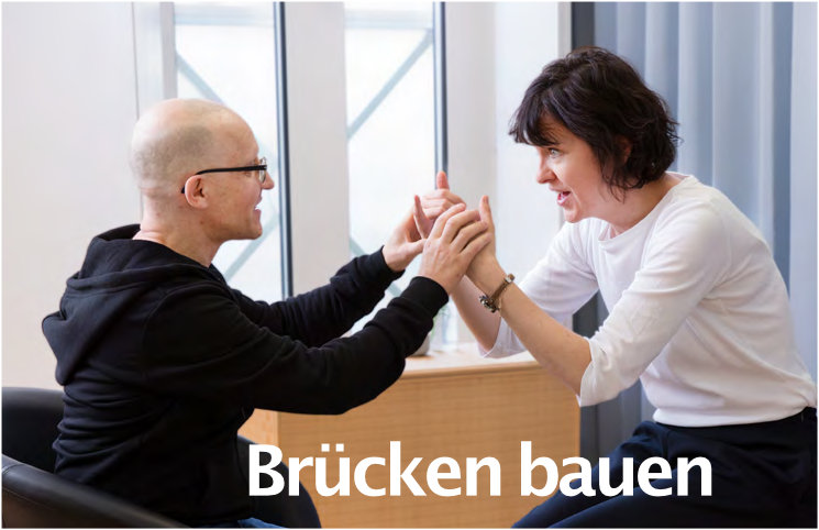 Taublindenassistenz Kommunikationssituation mit sich berührenden Händen und dem Bildtext "Brücken bauen"
